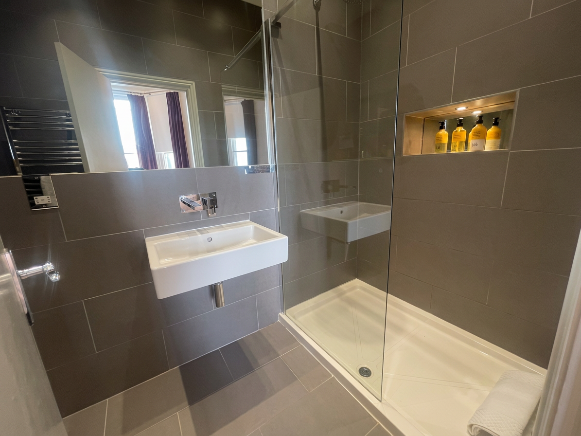 Hastings House ensuite bathroom with walk-in shower and lit toiletries niche